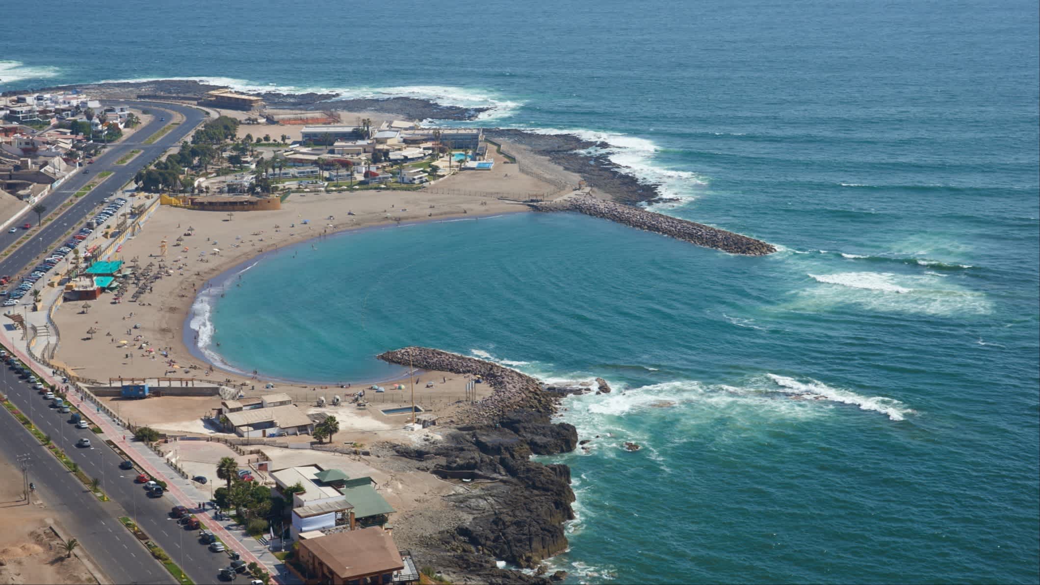 Der Strand El Laucho im Norden Chiles aus der Vogelperspektive mit Blick auf das Meer und die Bucht bei Sonnenschein.