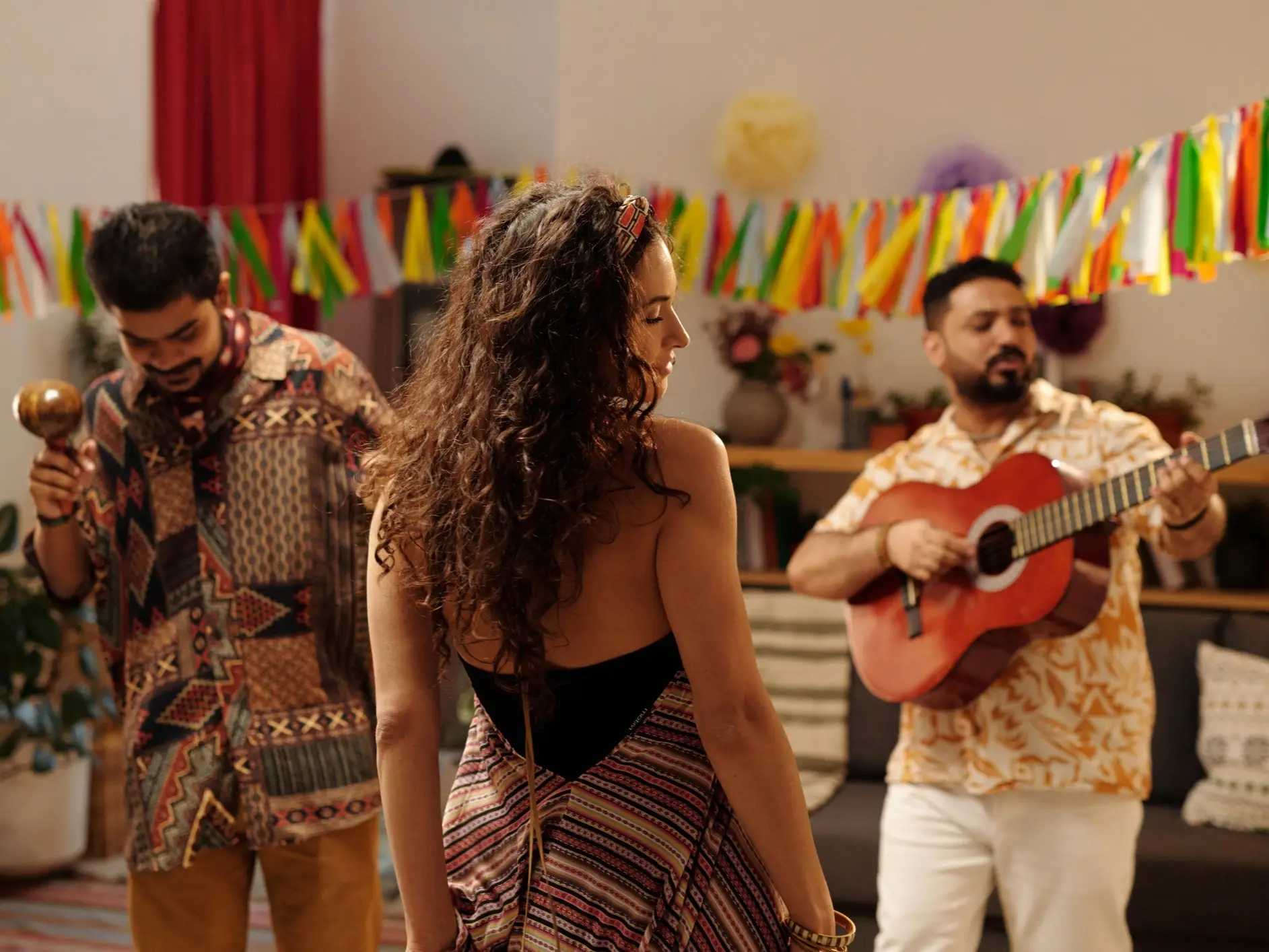 Groupe de musiciens et de danseurs lors d'une fête avec des décorations colorées.