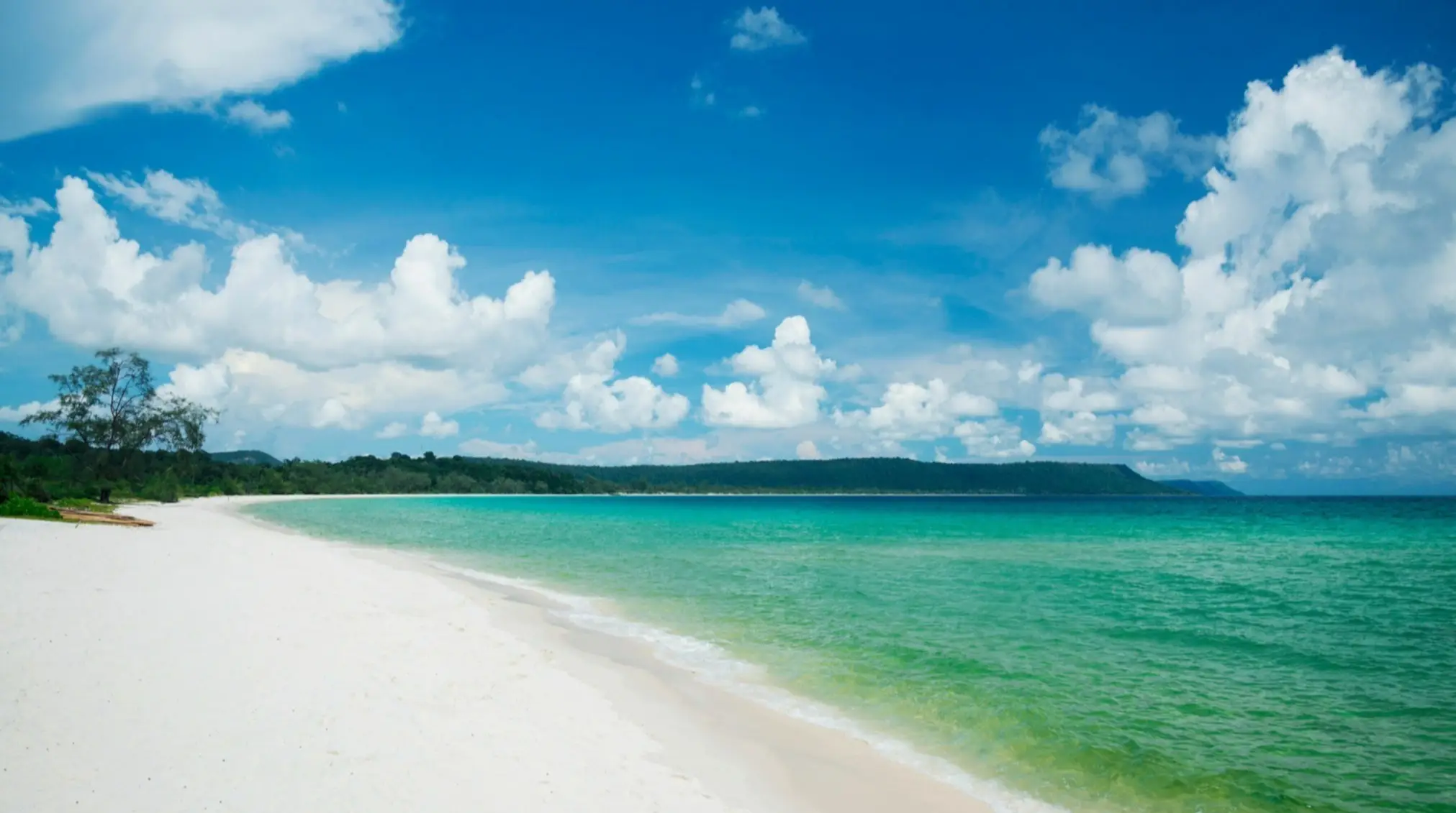 Weißer langer Sandstrand am grün blauen Wasser von Sok San Long Beach, Kambodscha bei herrlichem Wetter.