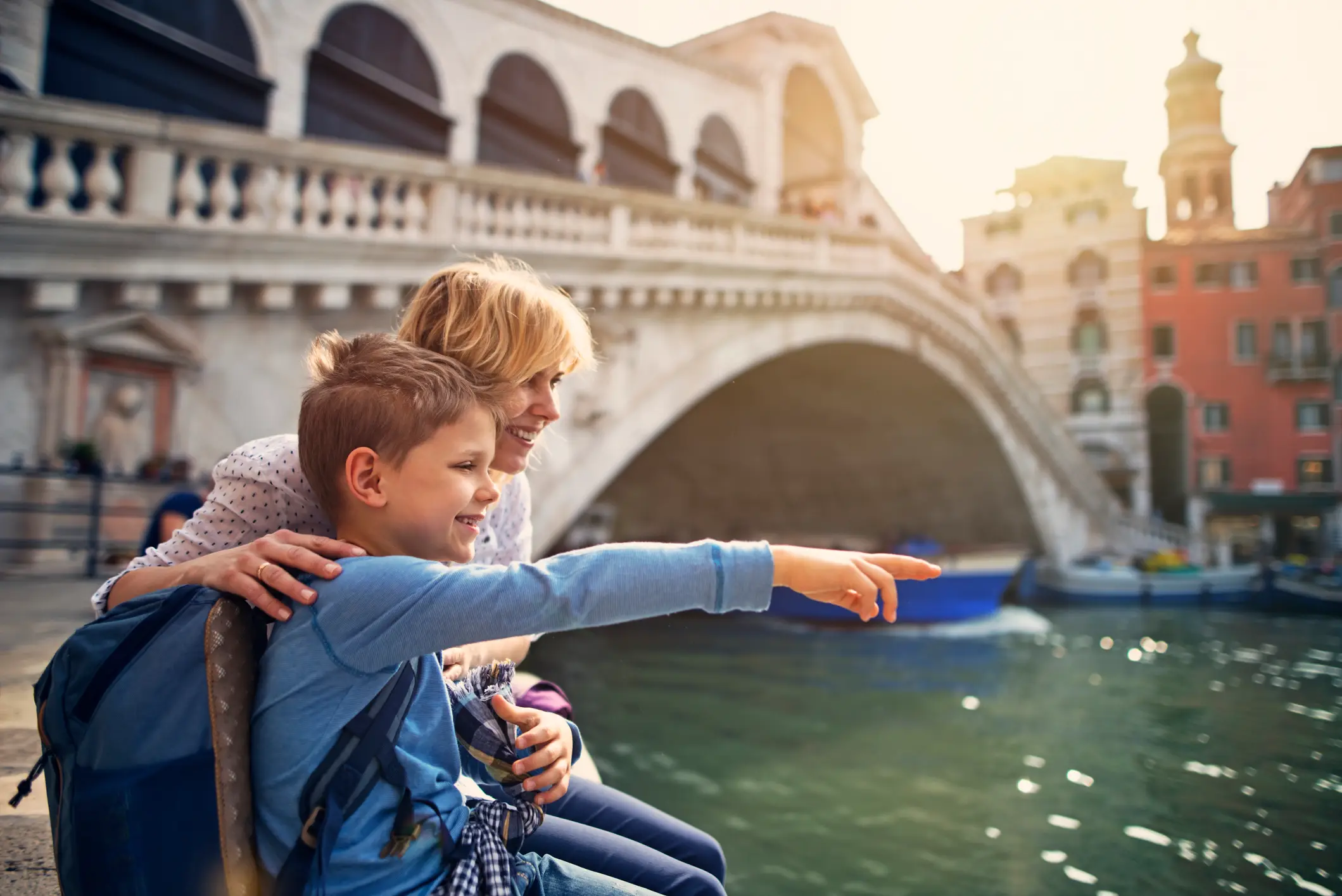 Italien, Venedig, Familienurlaub Mutter und Sohn besuchen Venedig, Italien. Sie sitzen am großen Kanal und die berühmte Rialto-Brücke ist im Hintergrund zu sehen.