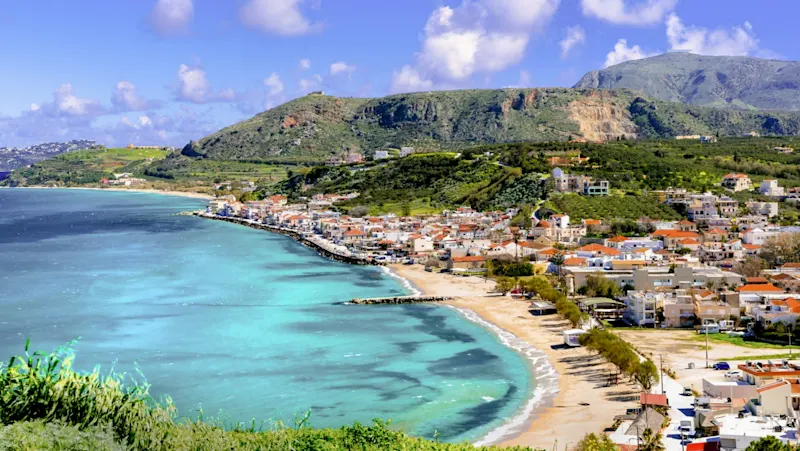 Greece, Crete, Kissamos Picturesque coastal town with clear water and green hills in Kissamos, Crete, Greece.