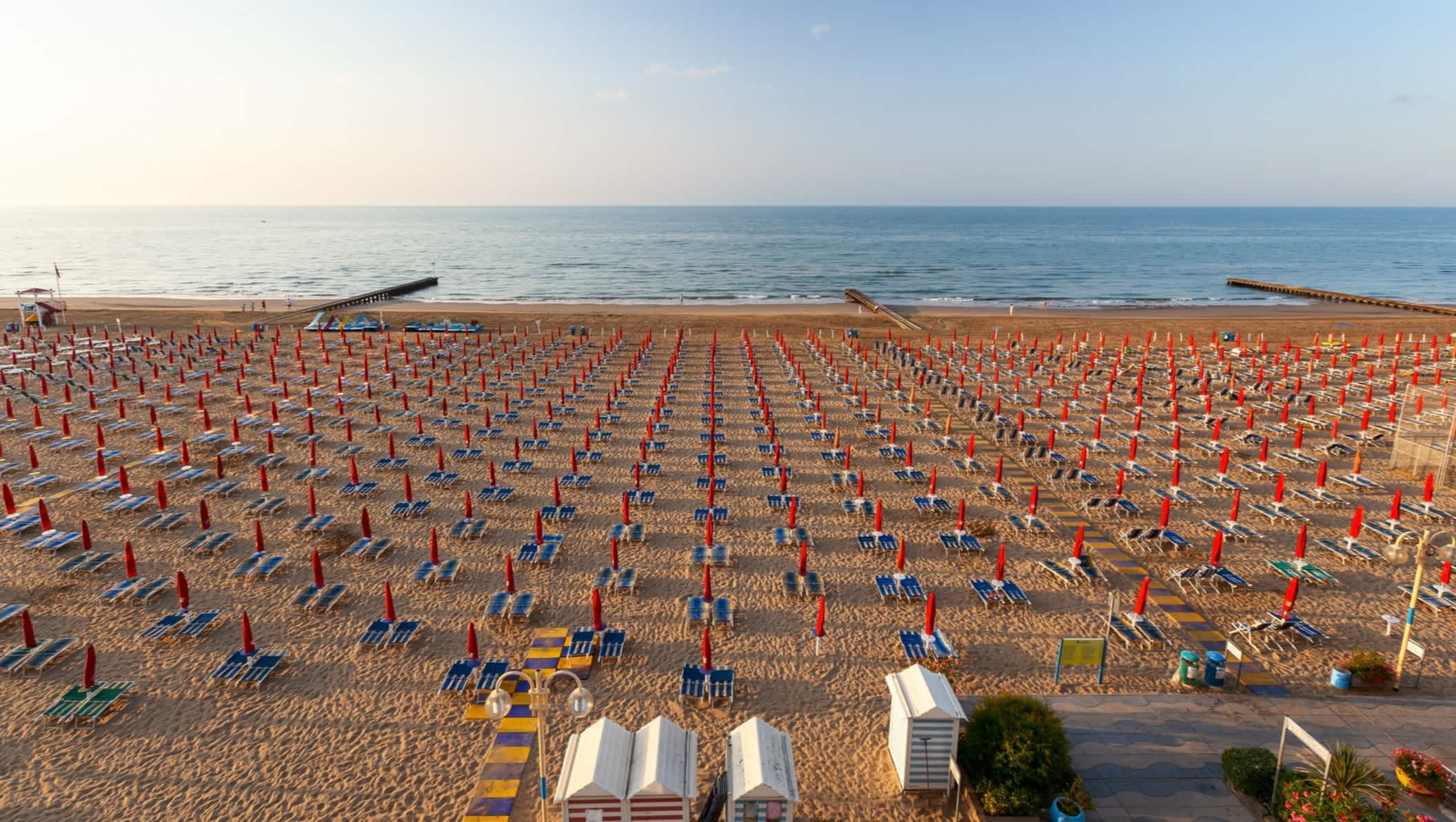 Vue sur la plage de Lido di Jesolo en Italie, avec des transats et parasols sur le sable au lever du soleil