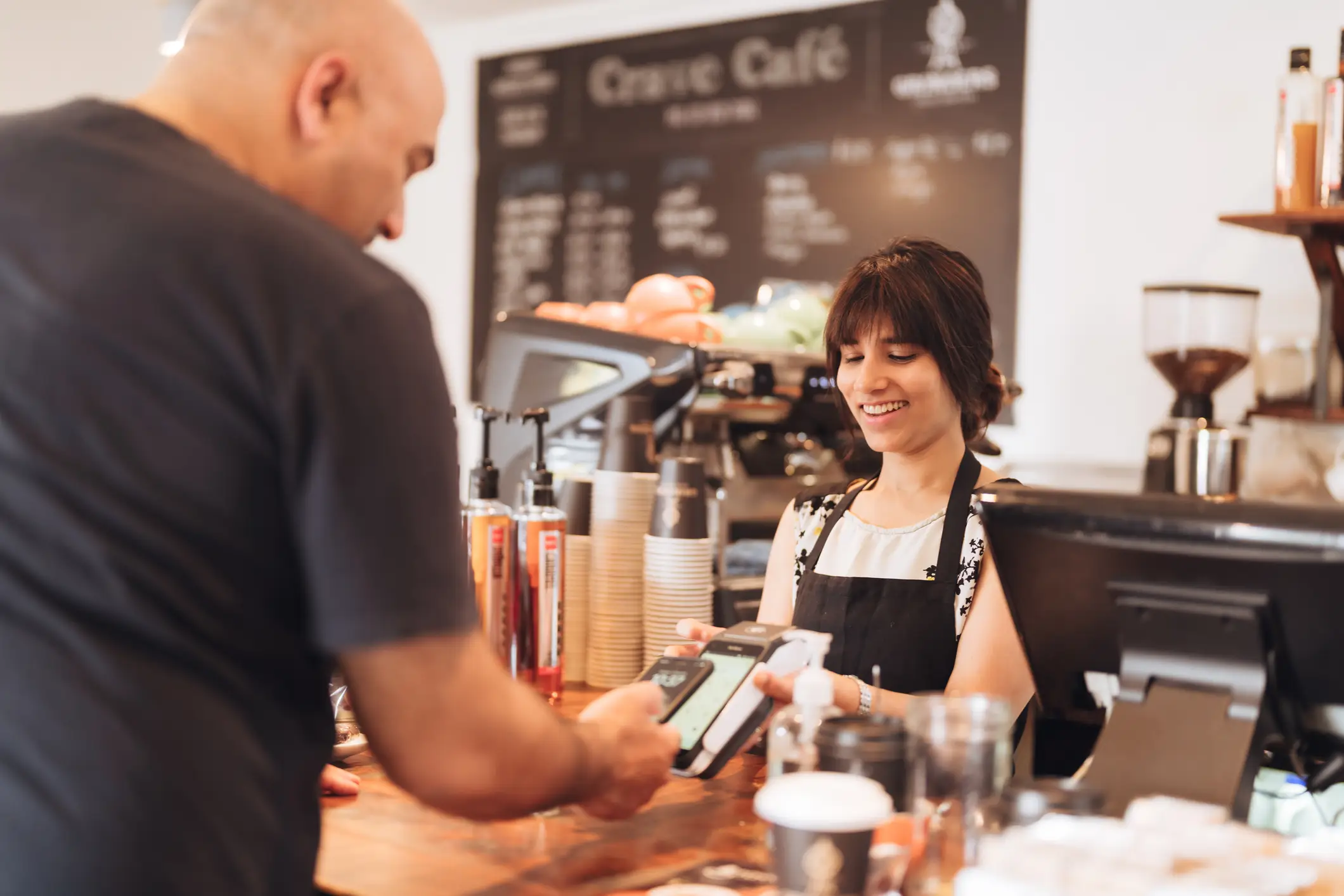 Paiement électronique par smartphone dans un café.