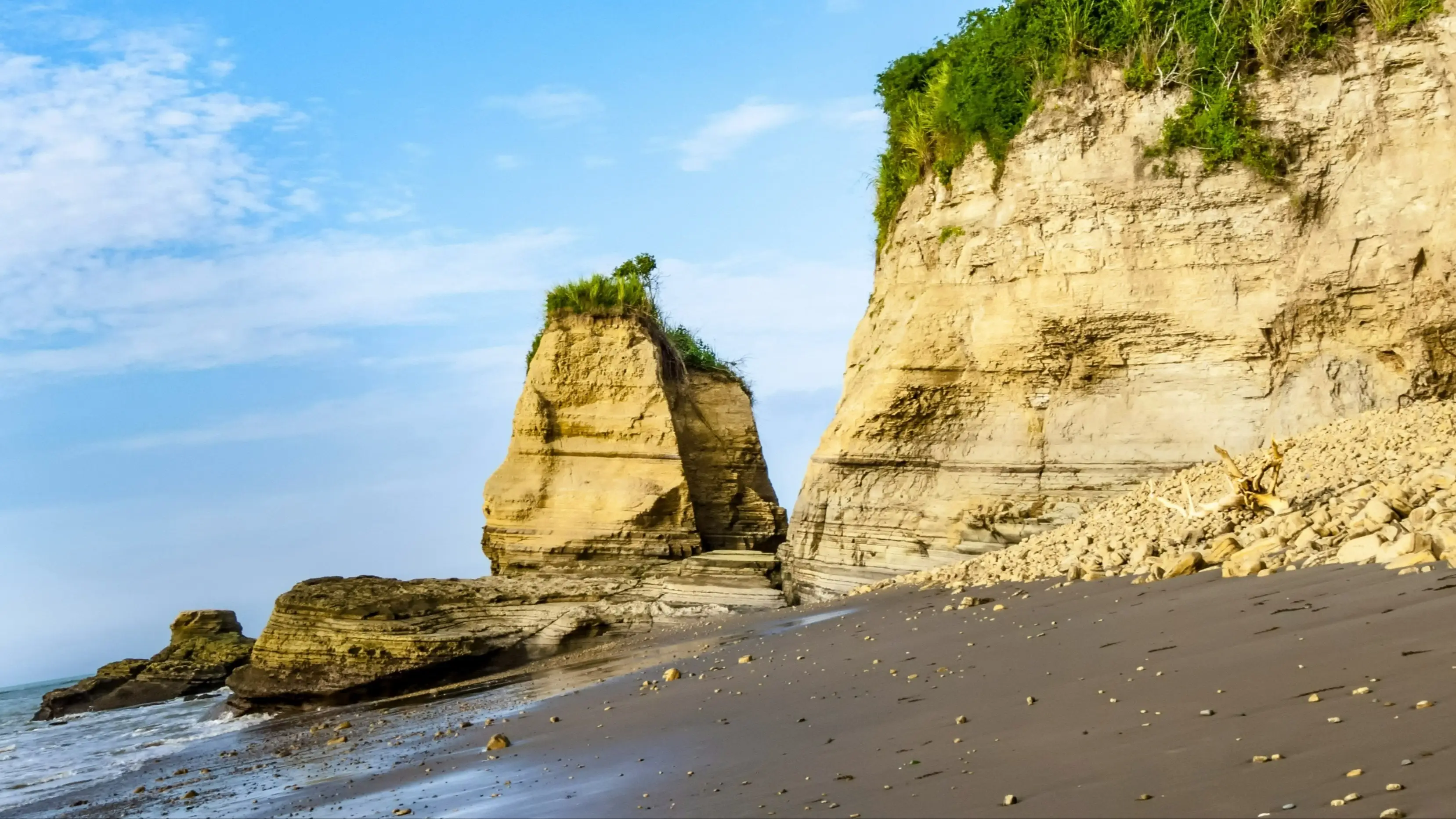 Équateur Atacames Roches sur le sable foncé de la plage d'Atacames, province d'Esmeraldas en Équateur