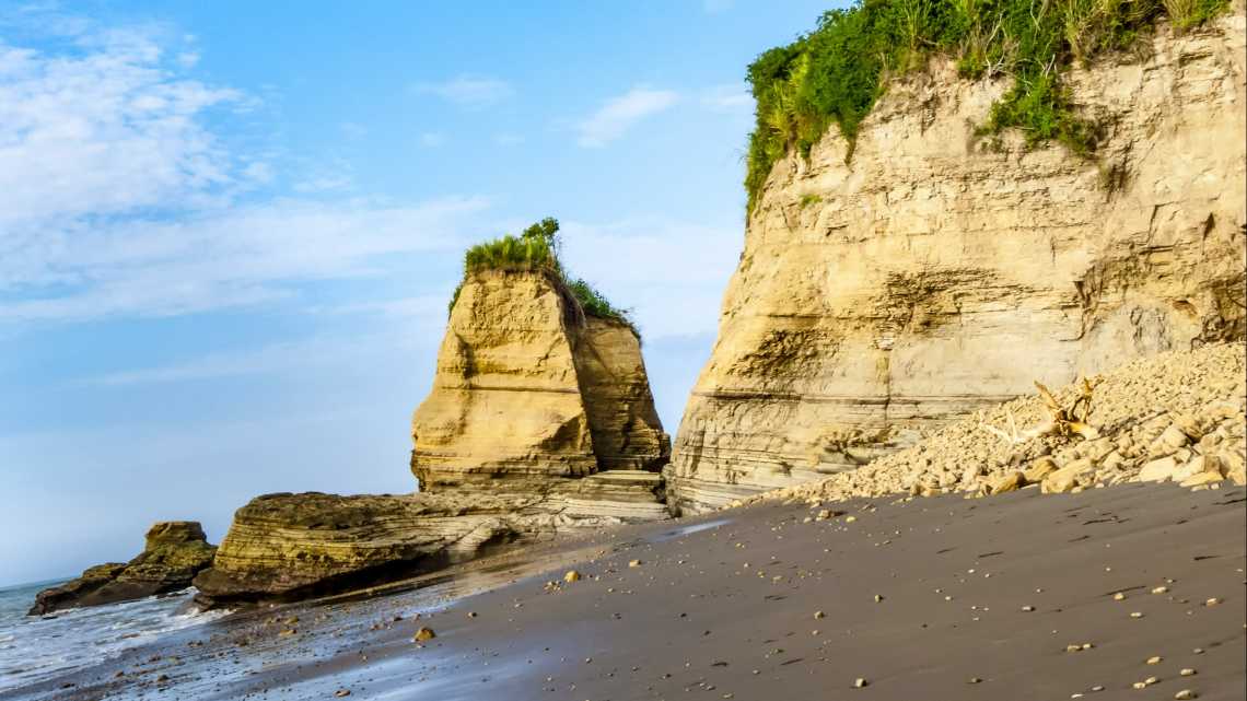 Roches sur le sable foncé de la plage d'Atacames, province d'Esmeraldas en Équateur