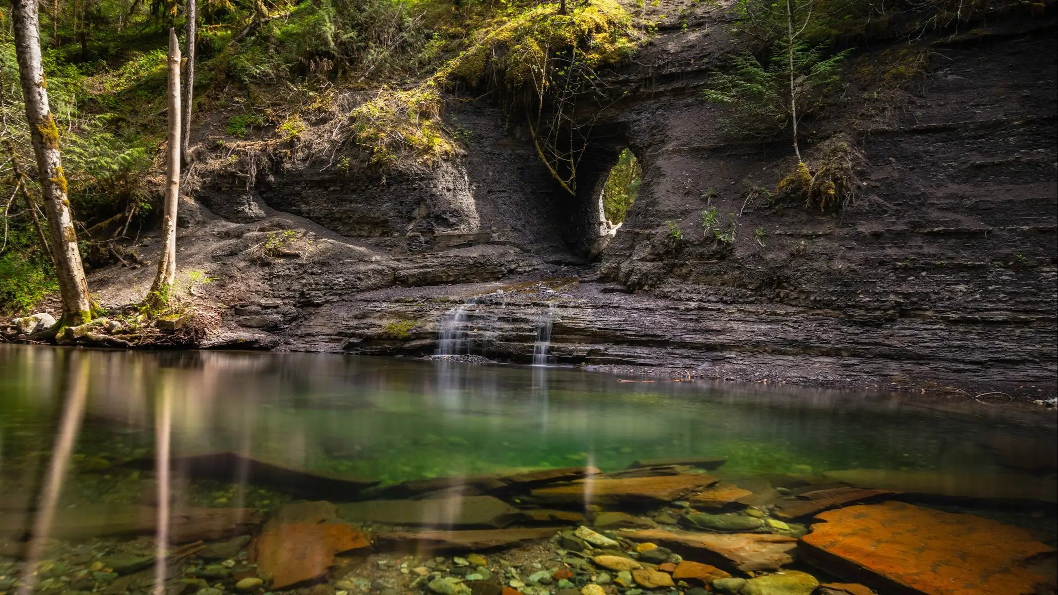 Gorge rocheuse avec percée naturelle en arc et eau claire, Port Alberni, Colombie-Britannique, Canada.