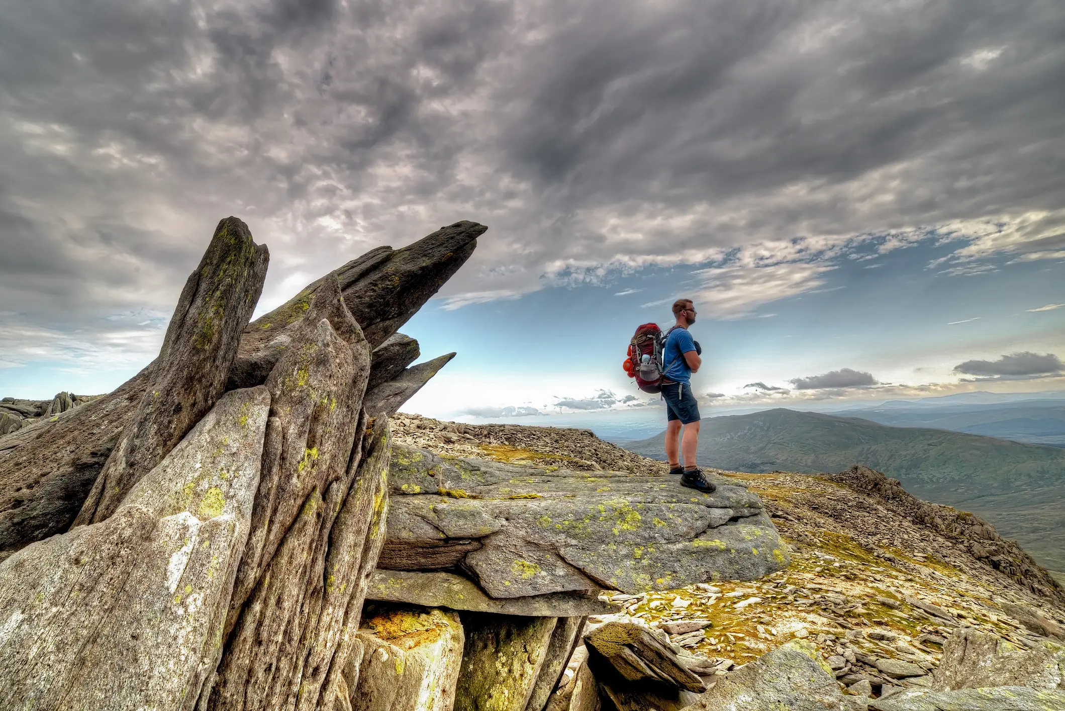Ein Wanderer erkundet den Gylder Fach hoch oben auf der Snowdonia Moutain Range in Wales, Großbritannien. 
