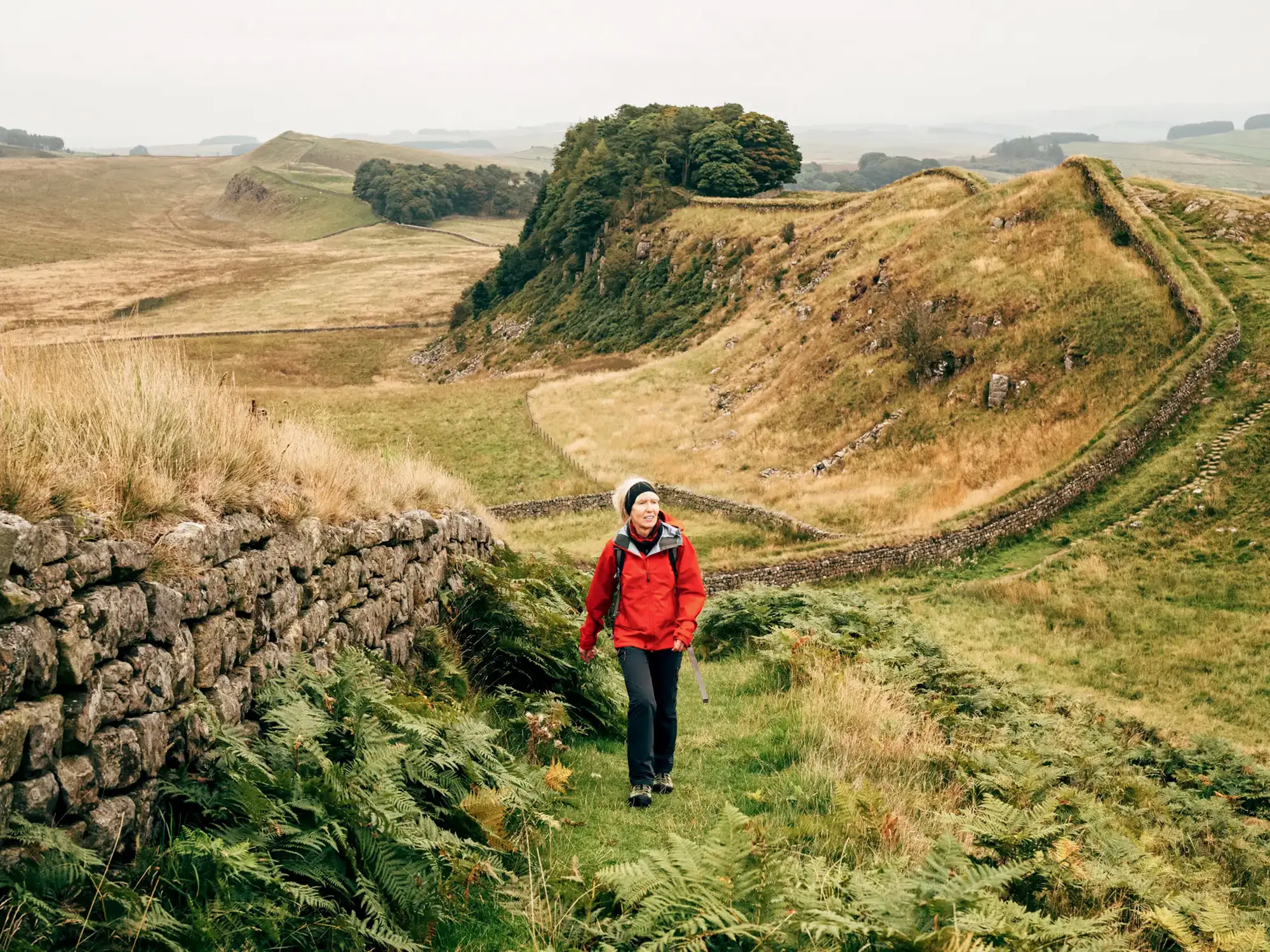 A woman walks along Hadrian's Wall, Brampton, England.