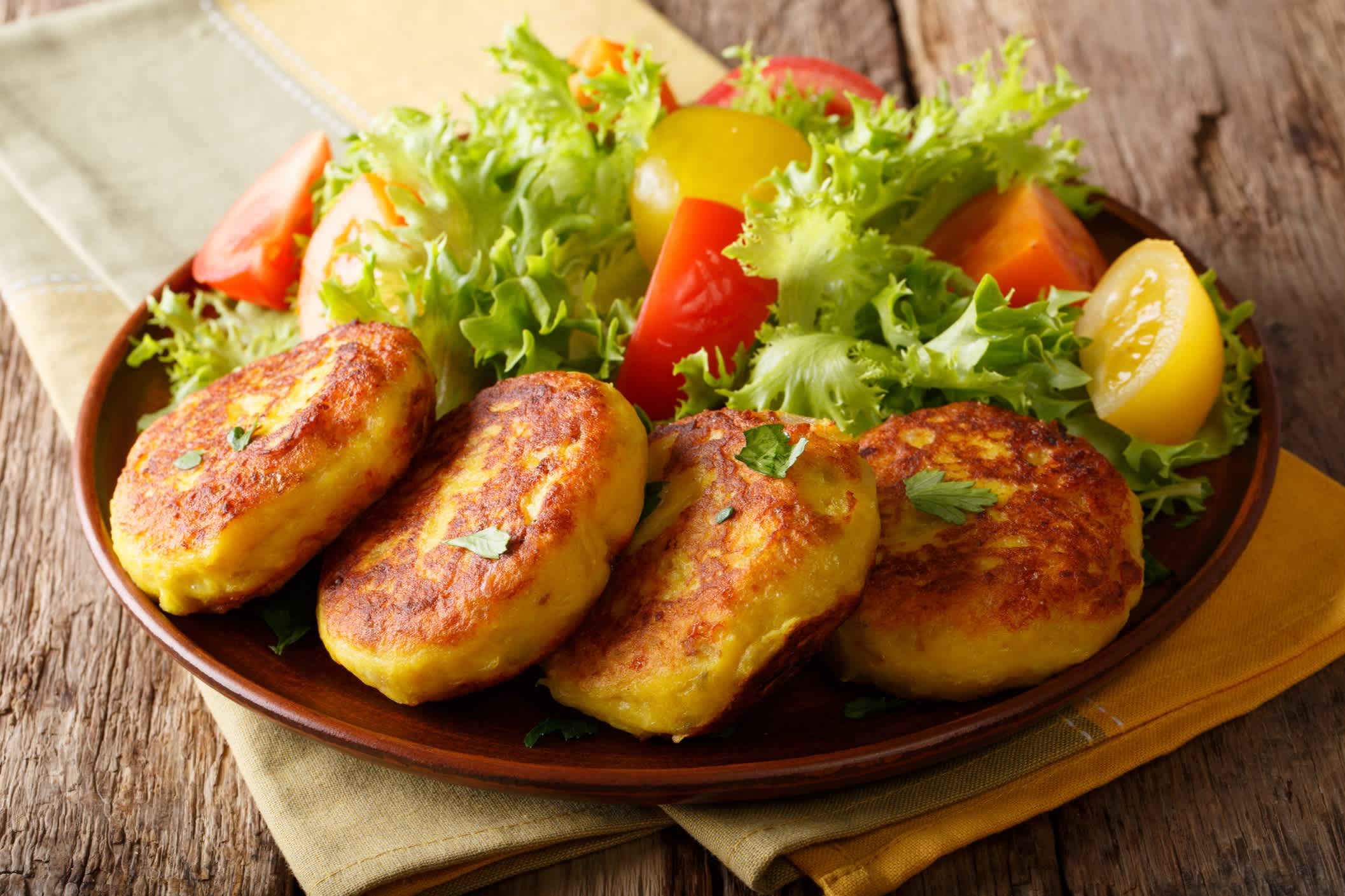 Serviert frische ecuadorianischen Kartoffel Pfannkuchen mit Salat aus frischem Gemüse Nahaufnahme auf einer Platte. horizontale