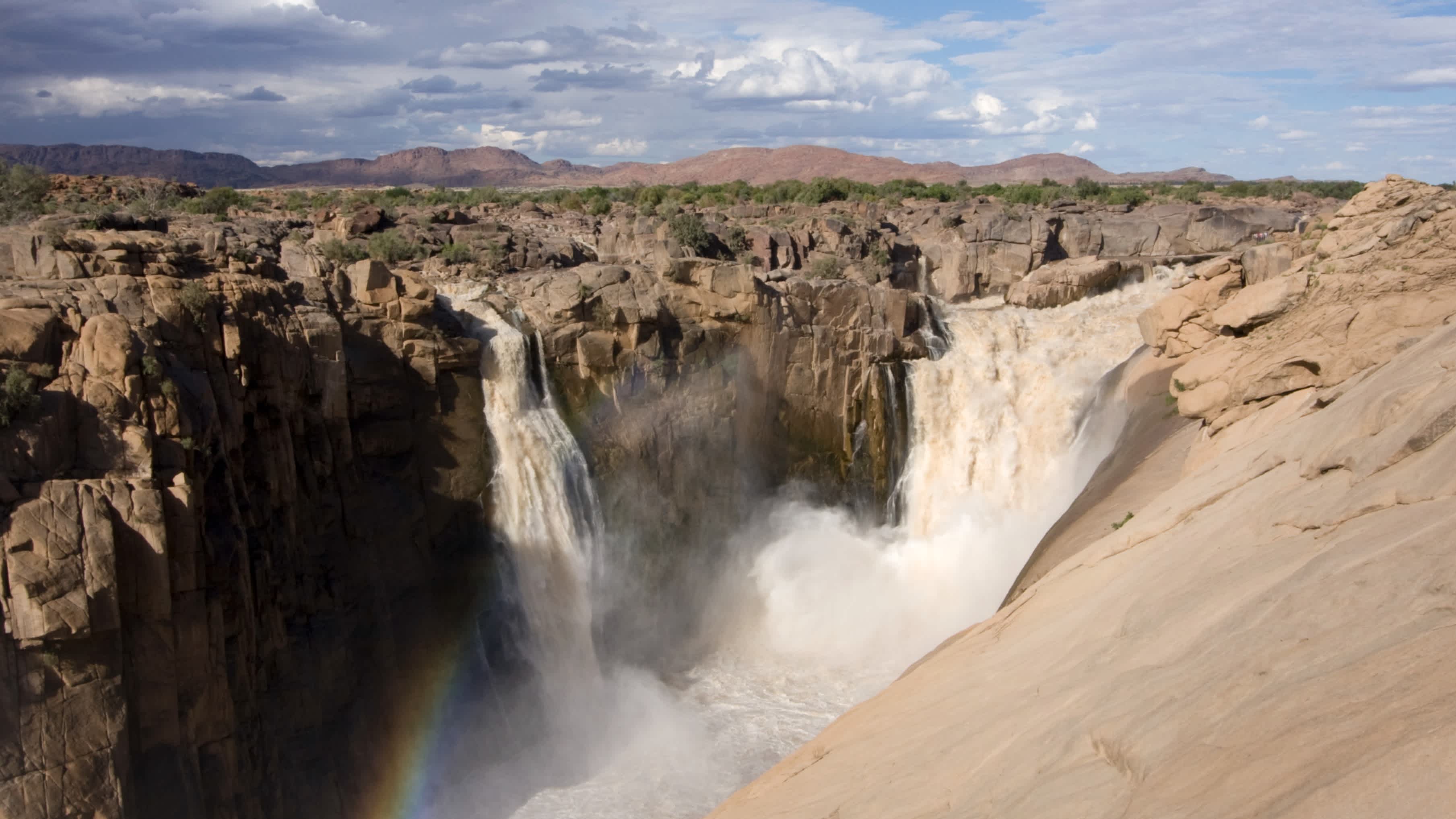 Blick über die Augrabie-Wasserfälle und einen Regenbogen in Südafrika 