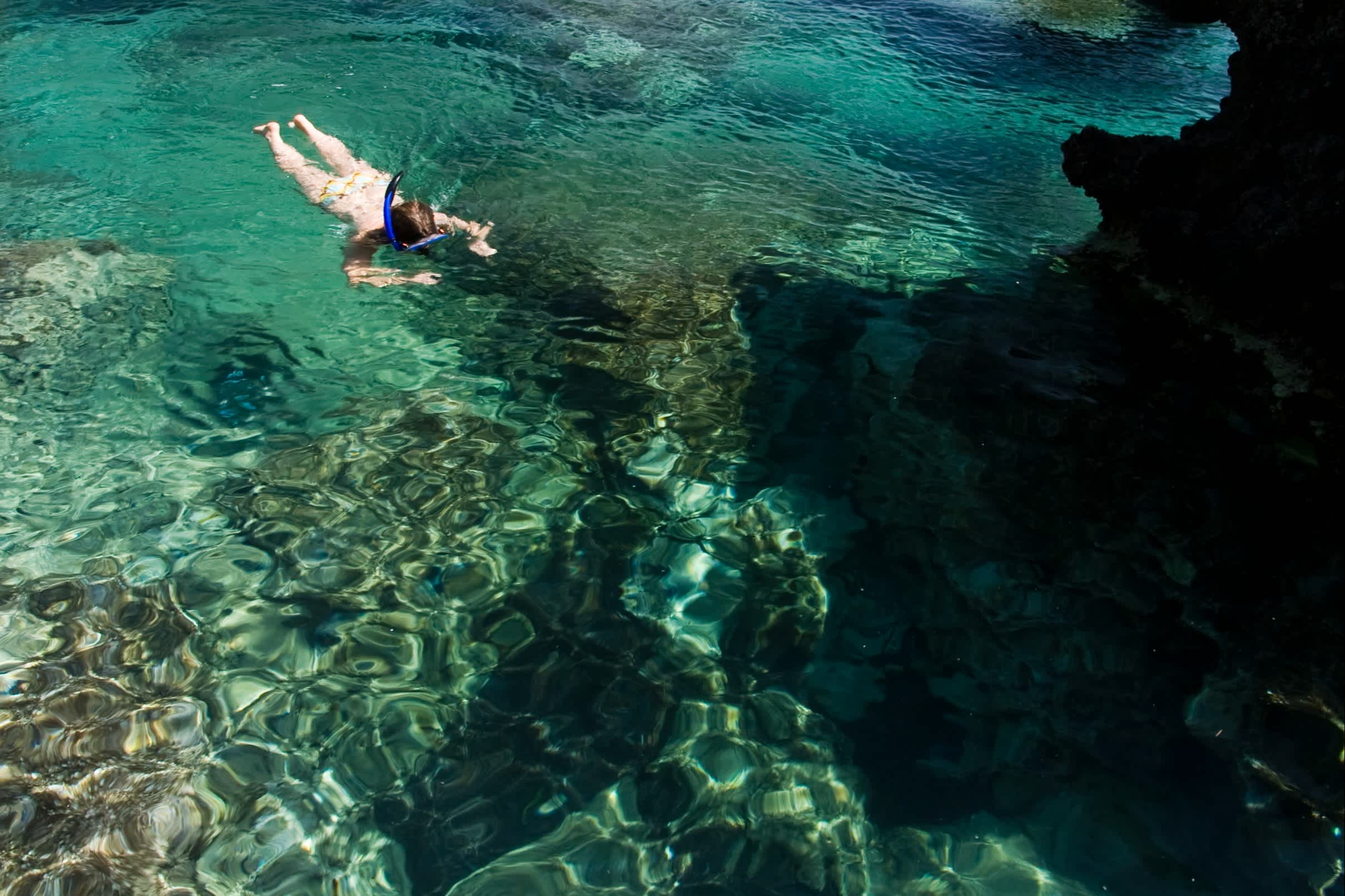 Une femme fait de la plongée avec un masque et un tuba en mer au large de l'île de Corfou, en Grèce