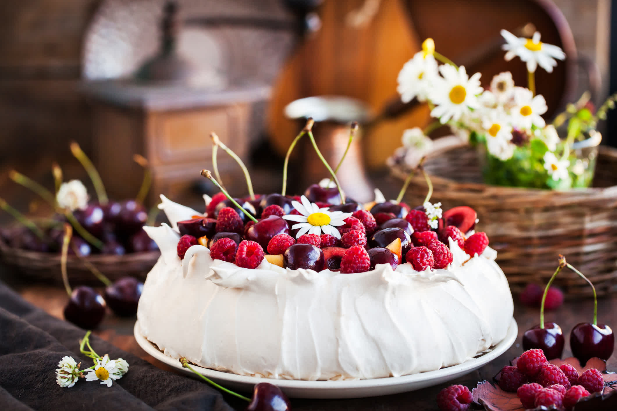 Délicieux gâteau Pavlova meringué décoré de framboises et de cerises fraîches.