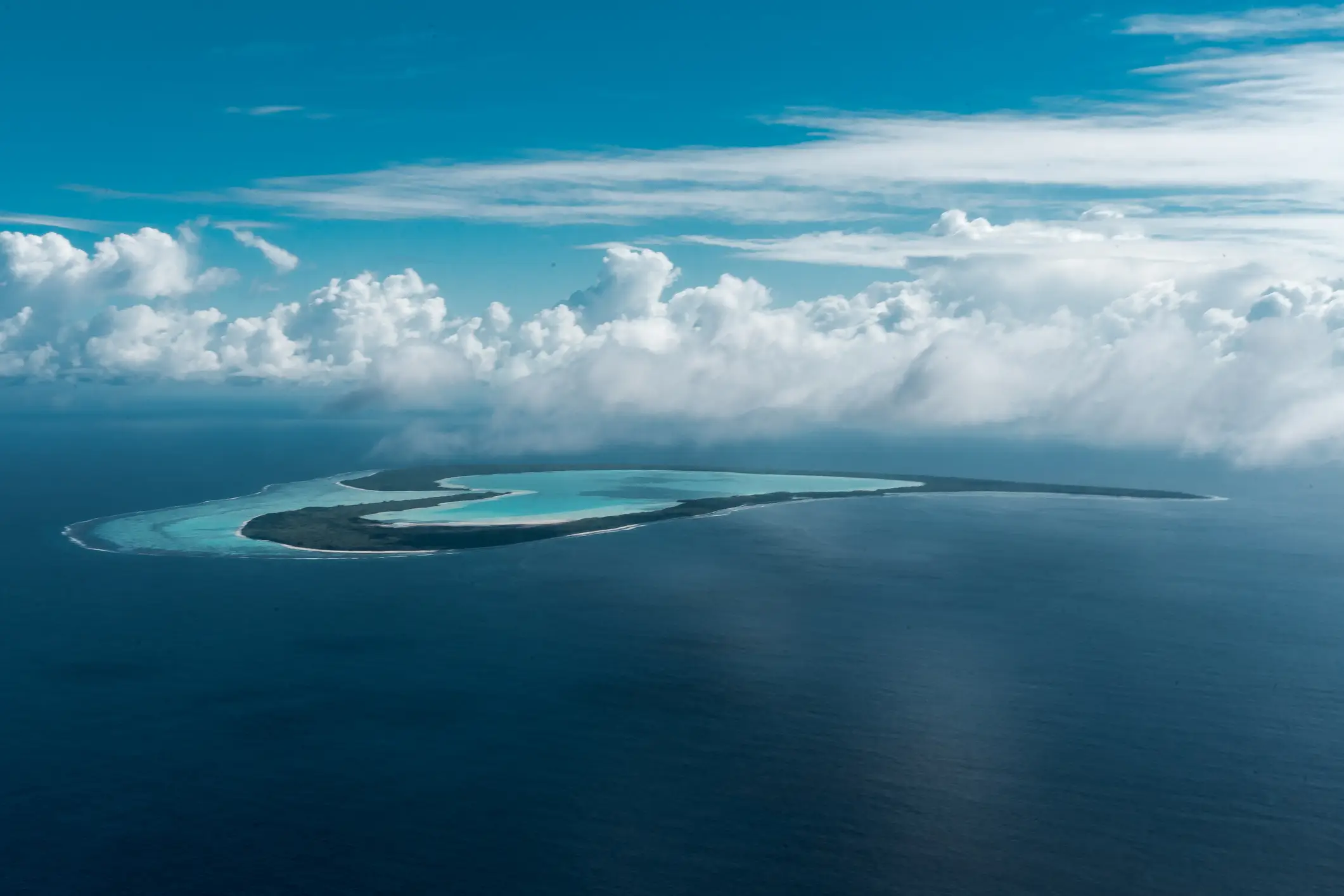 Vue aérienne de l'atoll de Tupai en forme de cœur, avec lagon turquoise entouré par l'océan, Polynésie Française.