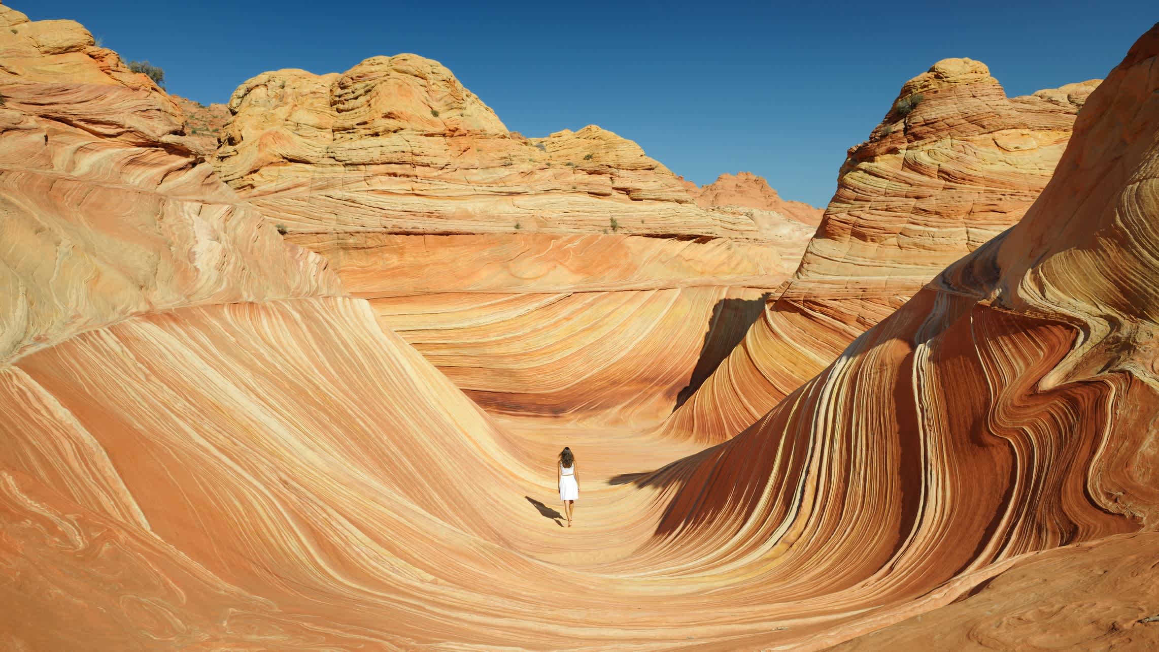 Eine Frau steht in der Mitte des Wave Rock in der Nähe der Stadt Hyden in Westaustralien.
 