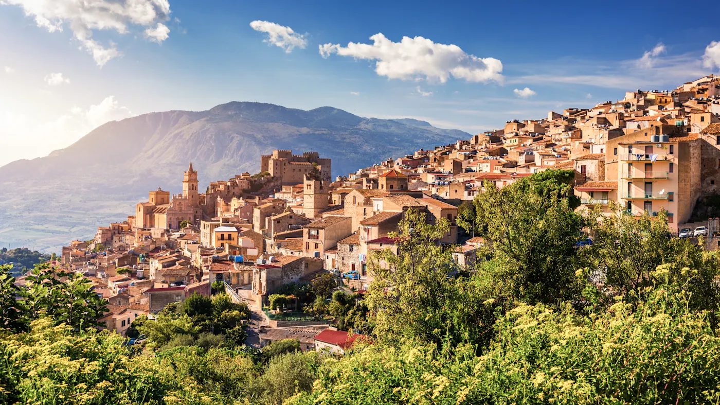 Italie, Sicile, Caccamo Ville historique sur une colline avec montagnes derrière. Caccamo, Sicile, Italie.