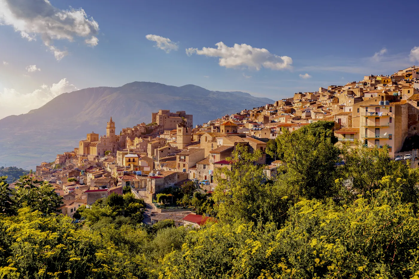 Historische Stadt auf einem Hügel mit Bergen im Hintergrund. Caccamo, Sizilien, Italien.