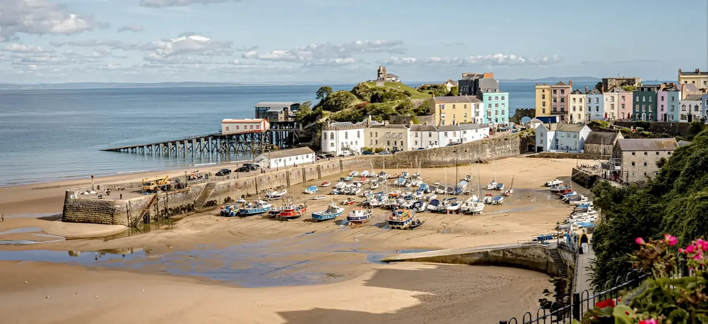 Wales, Pembrokeshire, Tenby Harbor with boats and colorful houses on the beach. Tenby, Pembrokeshire, Wales.