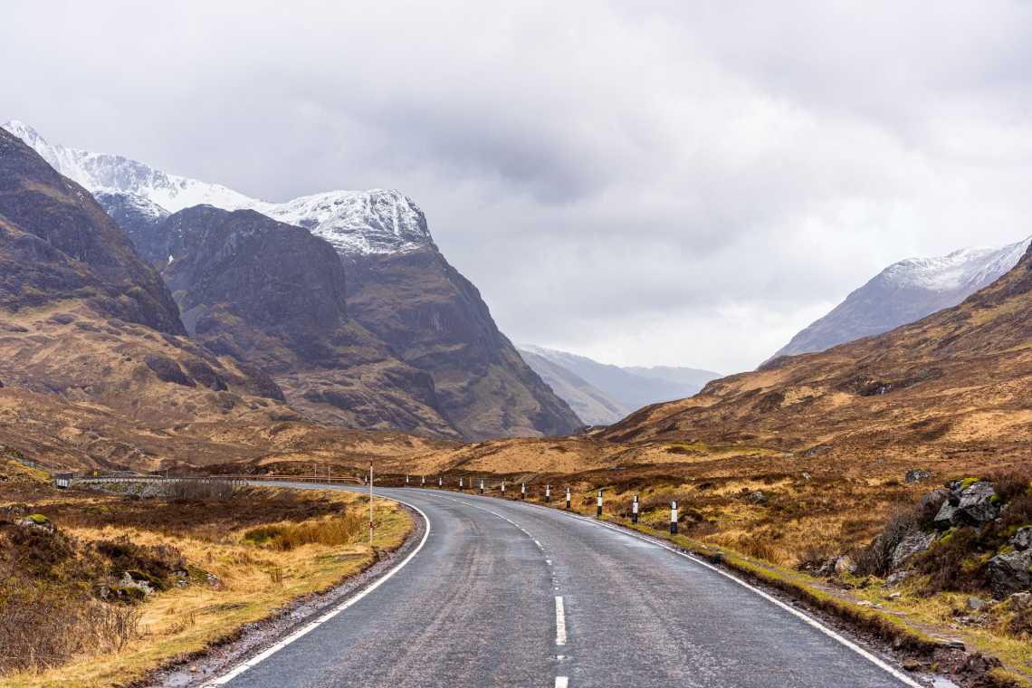 Die kurvenreiche Hauptstraße durch die historische Landschaft von Glencoe, Schottland. 

