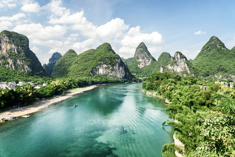 Wunderschöne Sommersonnige Landschaft im Yangshuo County von Guilin, China. Herrlicher Blick auf das Karstgebirge und den Fluss Li (Lijiang River) mit azurblauem Wasser. Schöne grüne Hügel auf blauem Himmelshintergrund.


