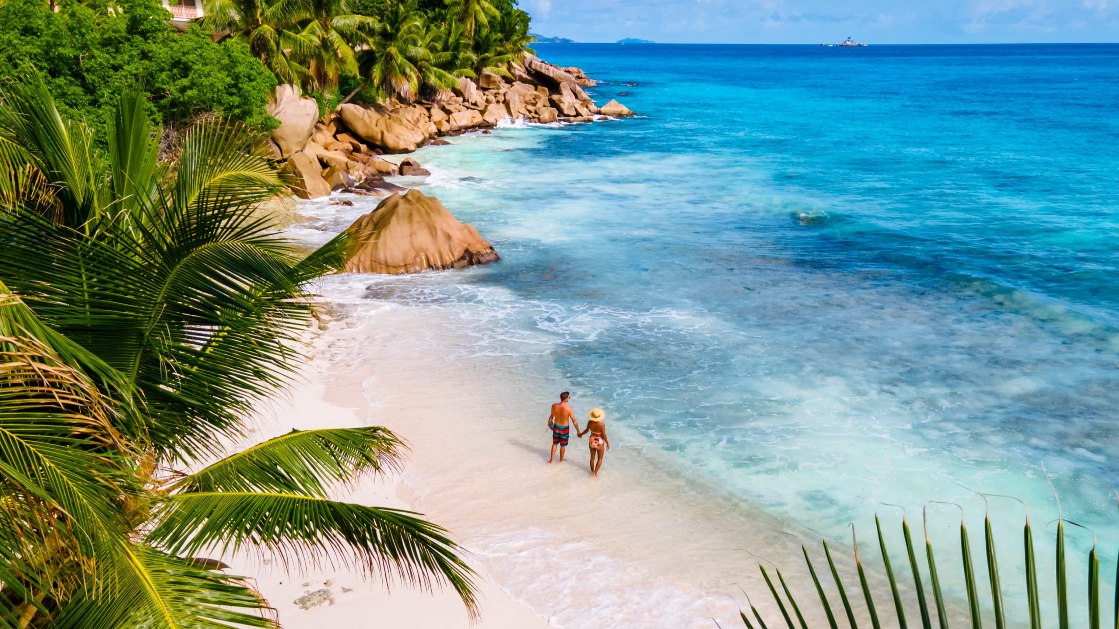 Un couple sur une plage d'Anse Source d'Argent à la Digue aux Seychelles.