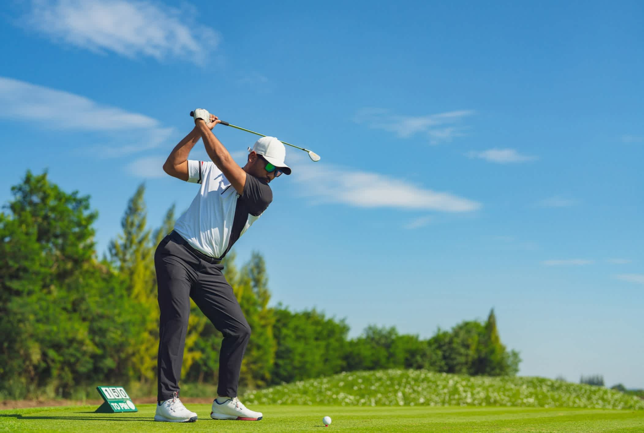 Un homme jouant au golf sur le parcours en été