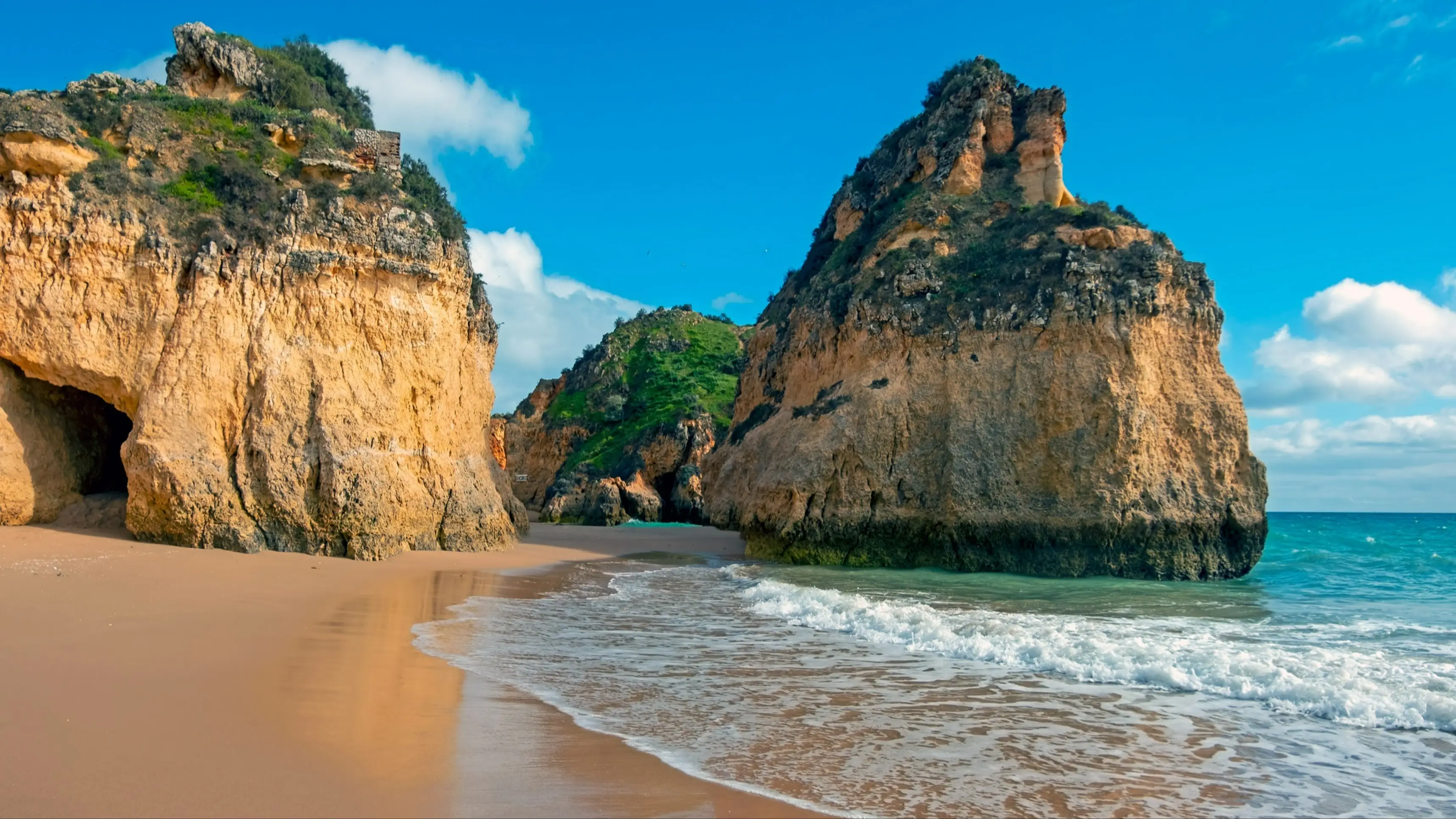 Praia Tres Irmaos, Alvor, Algarve Portugal Riesige Felsen an der Küste von Praia Tres Irmaos, Alvor, Algarve Portugal bei Sonnenschein.