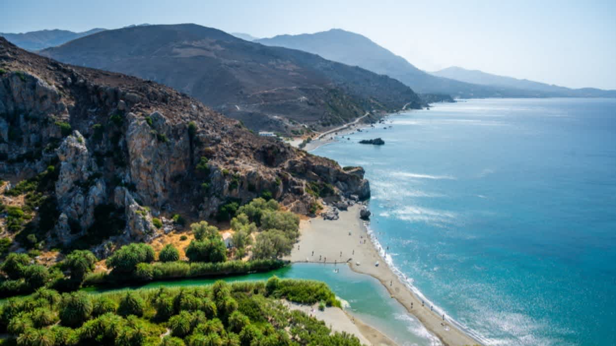 Blick aus der Luft auf den berühmten Preveli Strand auf Kreta, Griechenland mit Blick auf Meer und Berge.