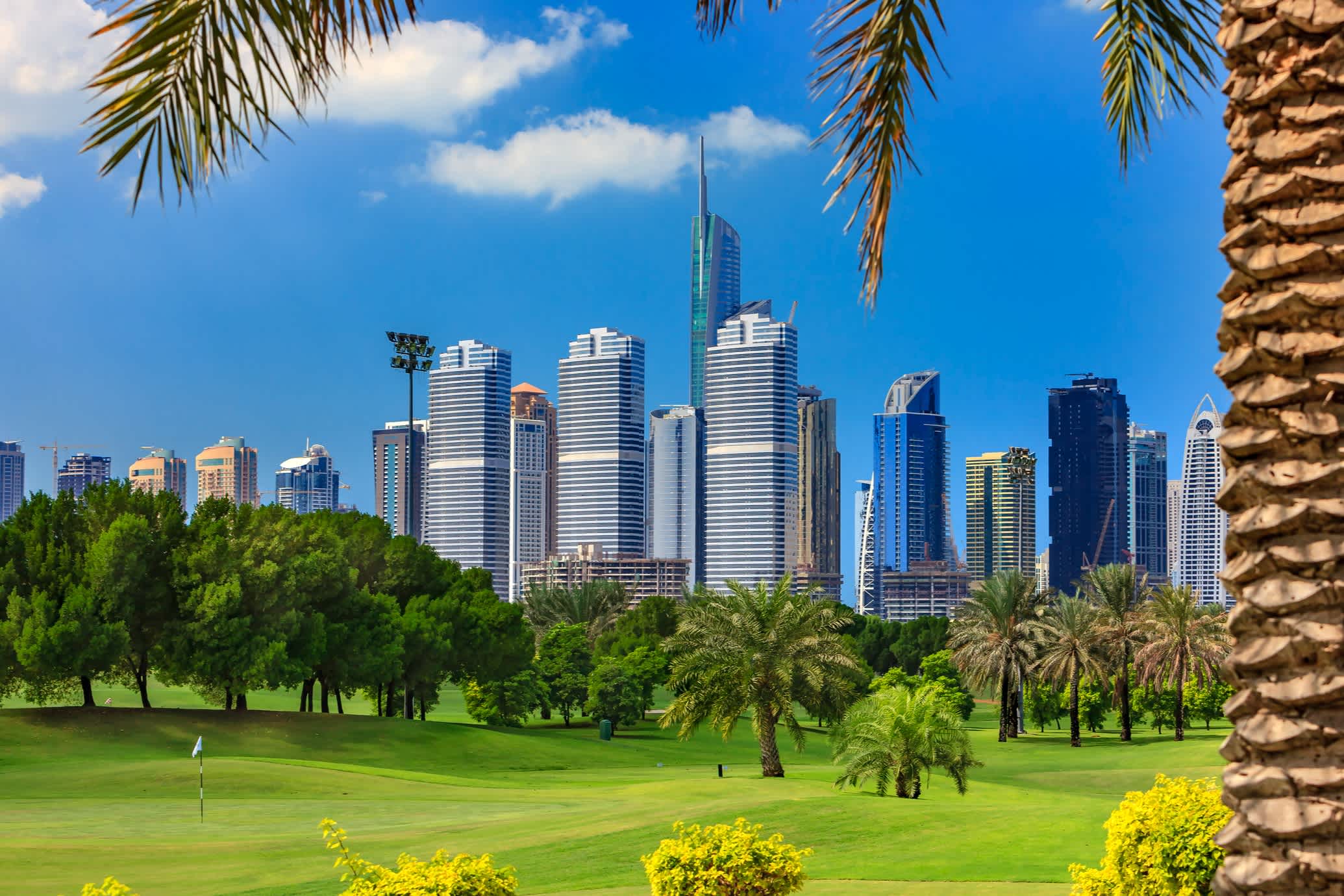 Golfplatz mit der Skyline Dubais im Hintergrund