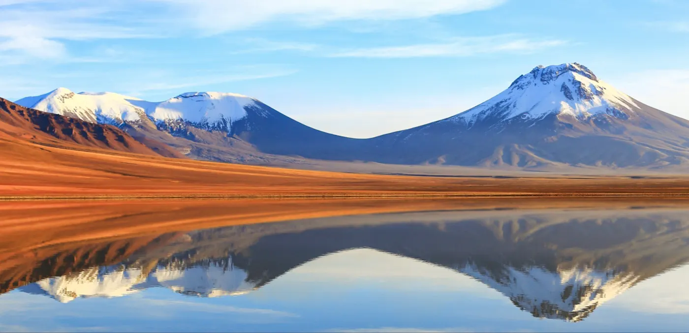 Schneebedeckte Berge spiegeln sich im See. San Pedro de Atacama, Antofagasta, Chile.