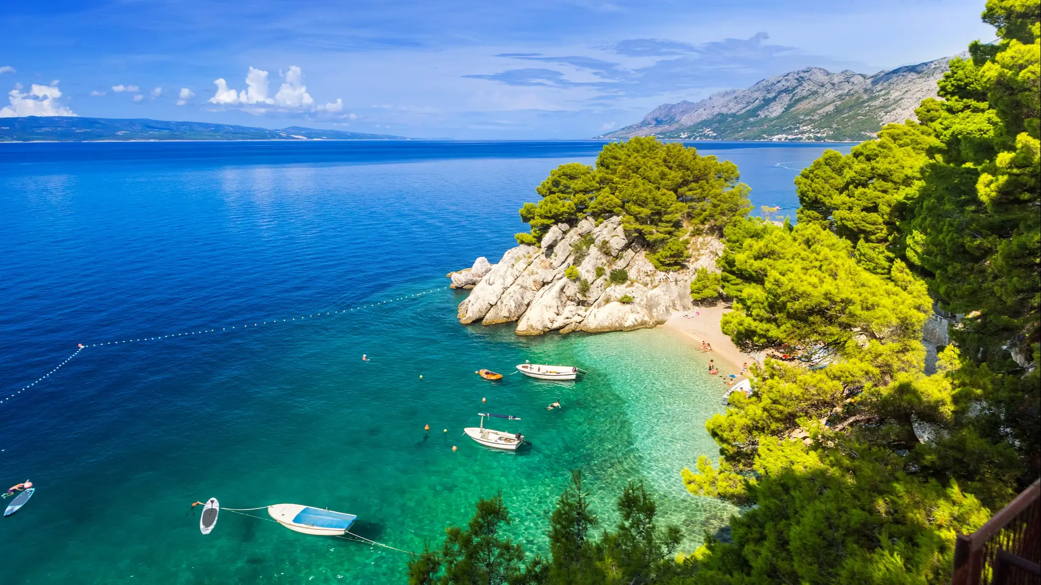 Kroatien Punta Rata Der Strand von Brela (Punta Rata), Kroatien mit Blick durch Felsen auf einen großen Felsen im Wasser.