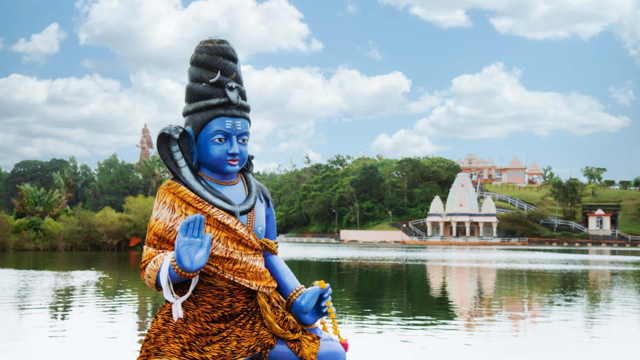 Statue bleue de Shiva au premier plan avec le lac de cratère Grand Bassin en arrière-plan, Maurice