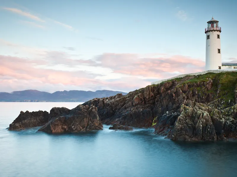 Irland, Donegal, Fanad, Leuchtturm Leuchtturm auf felsiger Küste mit Bergen im Hintergrund. Fanad, Donegal, Irland.