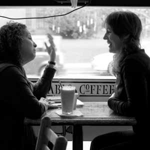Two people having a conversation in a cafe.