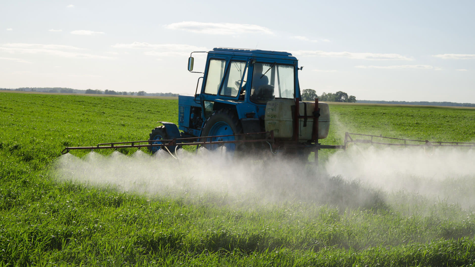 Tractor spraying chemicals on crops