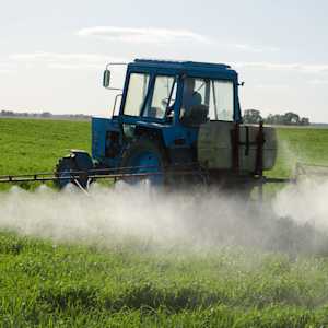 Tractor spraying chemicals on crops