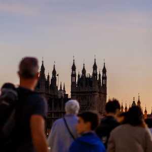 People walking over Westminster Bridge towards the UK Houses of Parliament