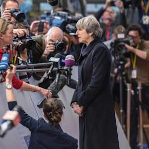 Theresa May being accosted buy jouirnalists after an EU Council Summit