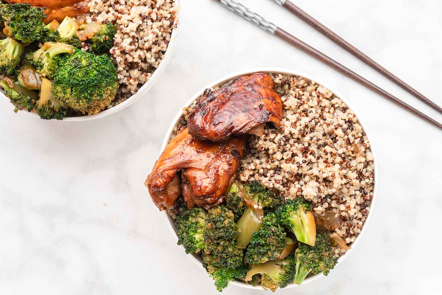 Sticky chicken and broccoli with quinoa in a bowl with chopsticks
