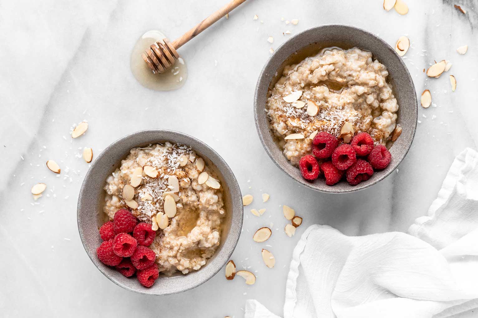 Overnight multigrain porridge in bowl topped with fresh raspberries and almonds