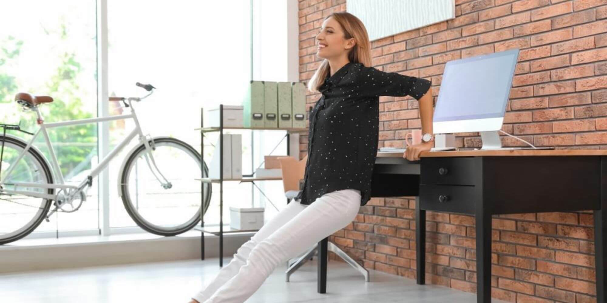 Smiling woman doing dip exercises at her desk in her home