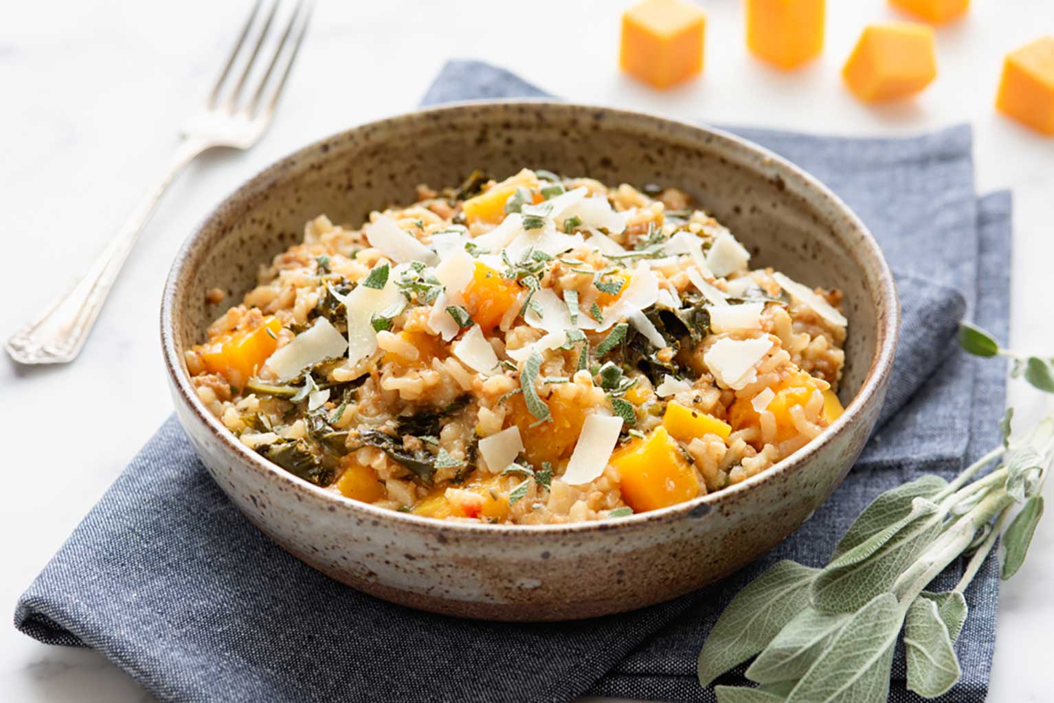 Risotto with butternut squash, sausage, and kale topped with fresh sage