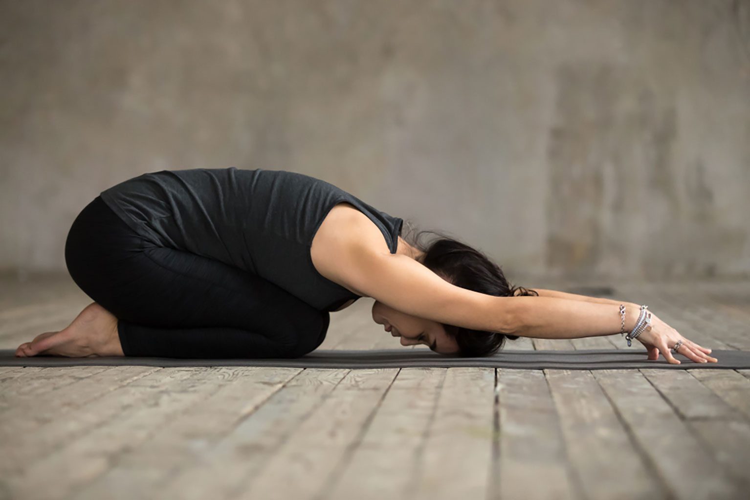 Young woman practicing the child’s yoga pose