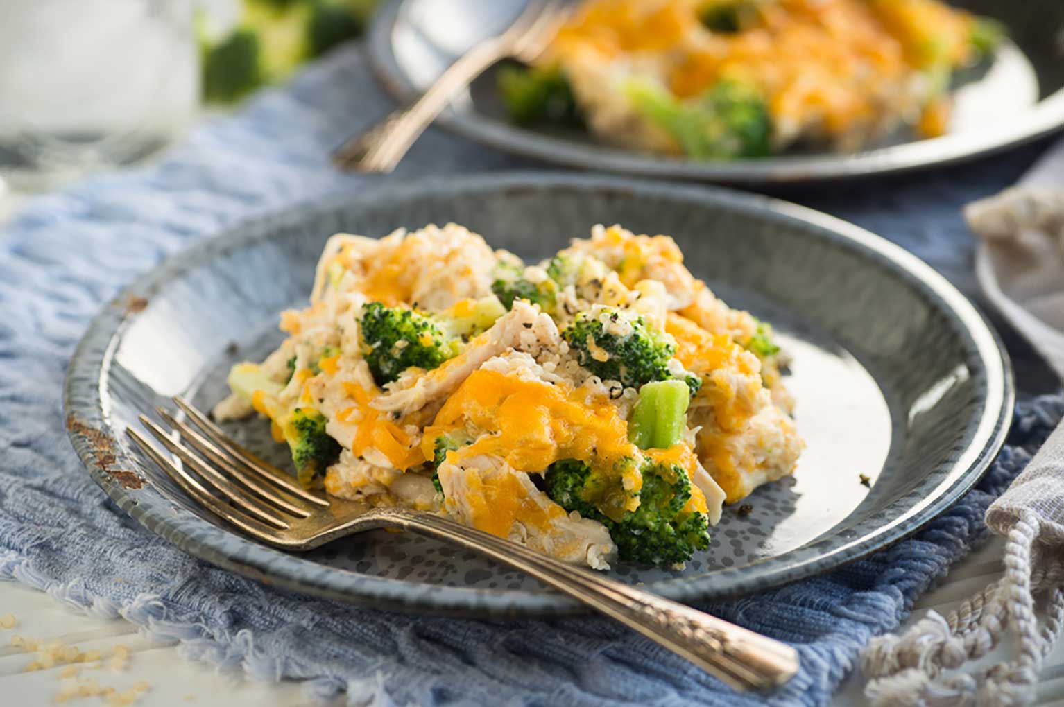 Quinoa casserole with chicken, broccoli, and cheese on a plate with fork