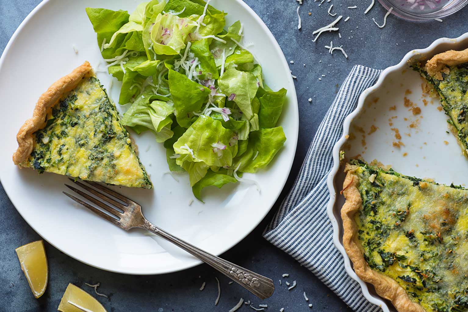 Zucchini Parmesan quiche with side salad on plate with fork