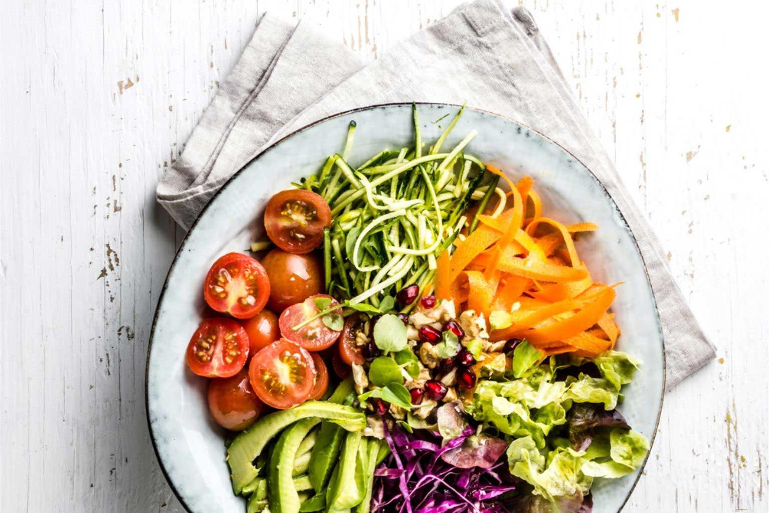 healthy salad with avocado, tomatoes, bell peppers, and fresh vegetables in a bowl