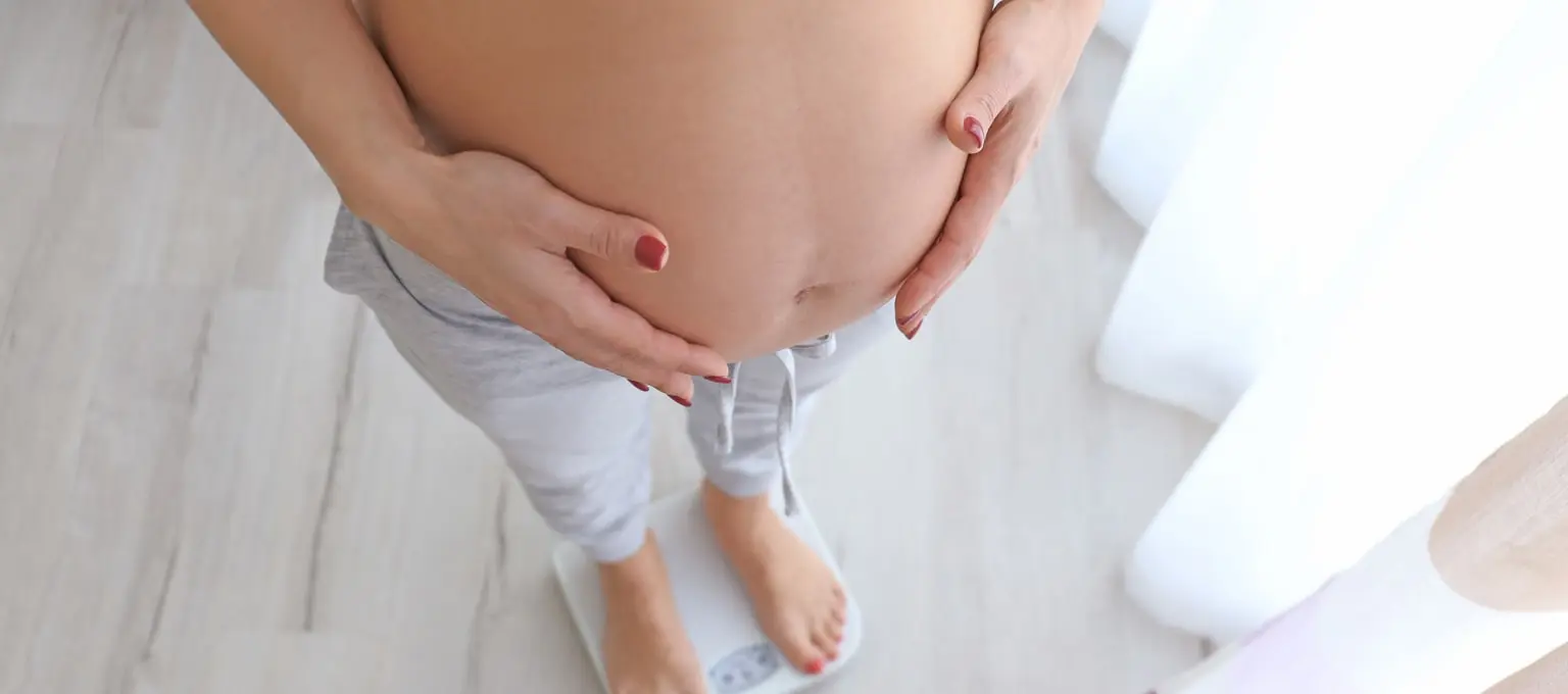 Kobieta w ciąży stojąca na wadze