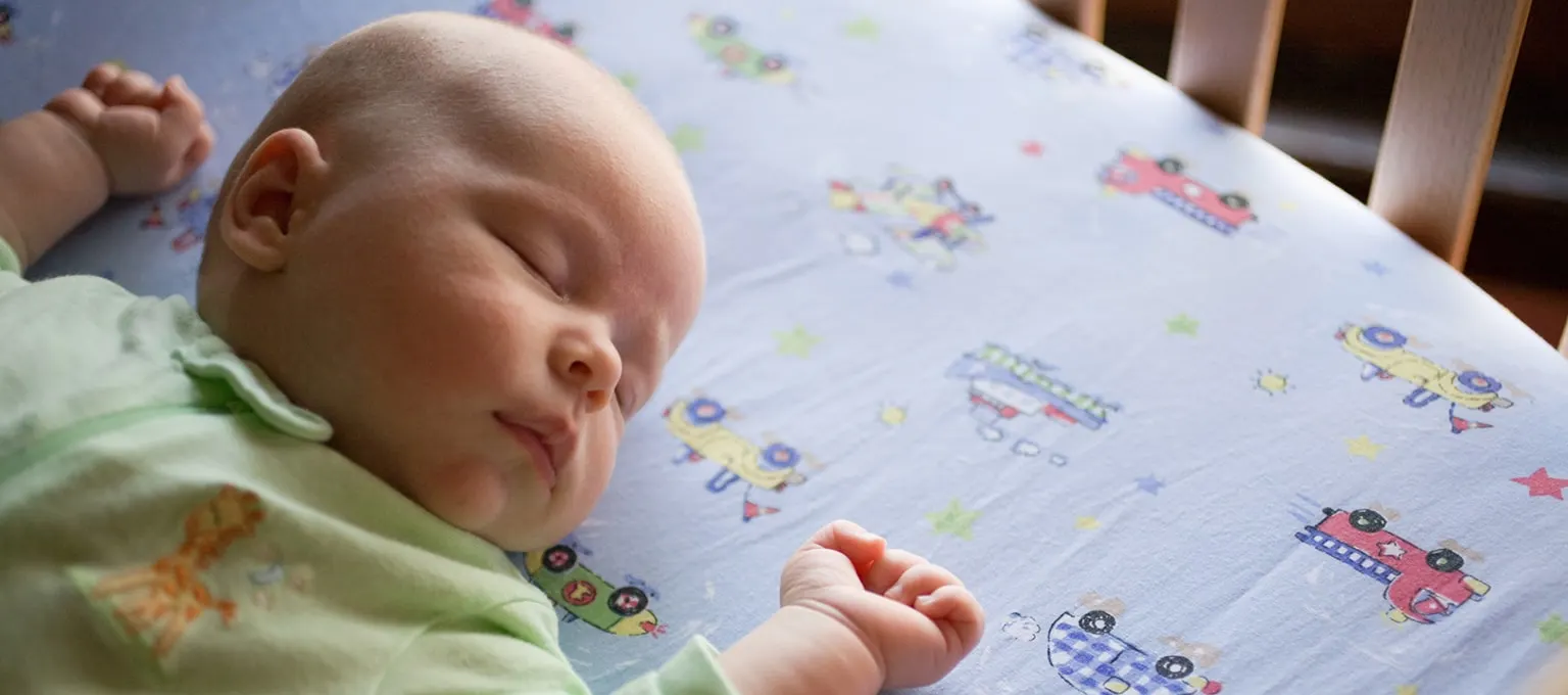 Jak zapobiegać SIDS? Niemowlę śpiące w łóżeczku