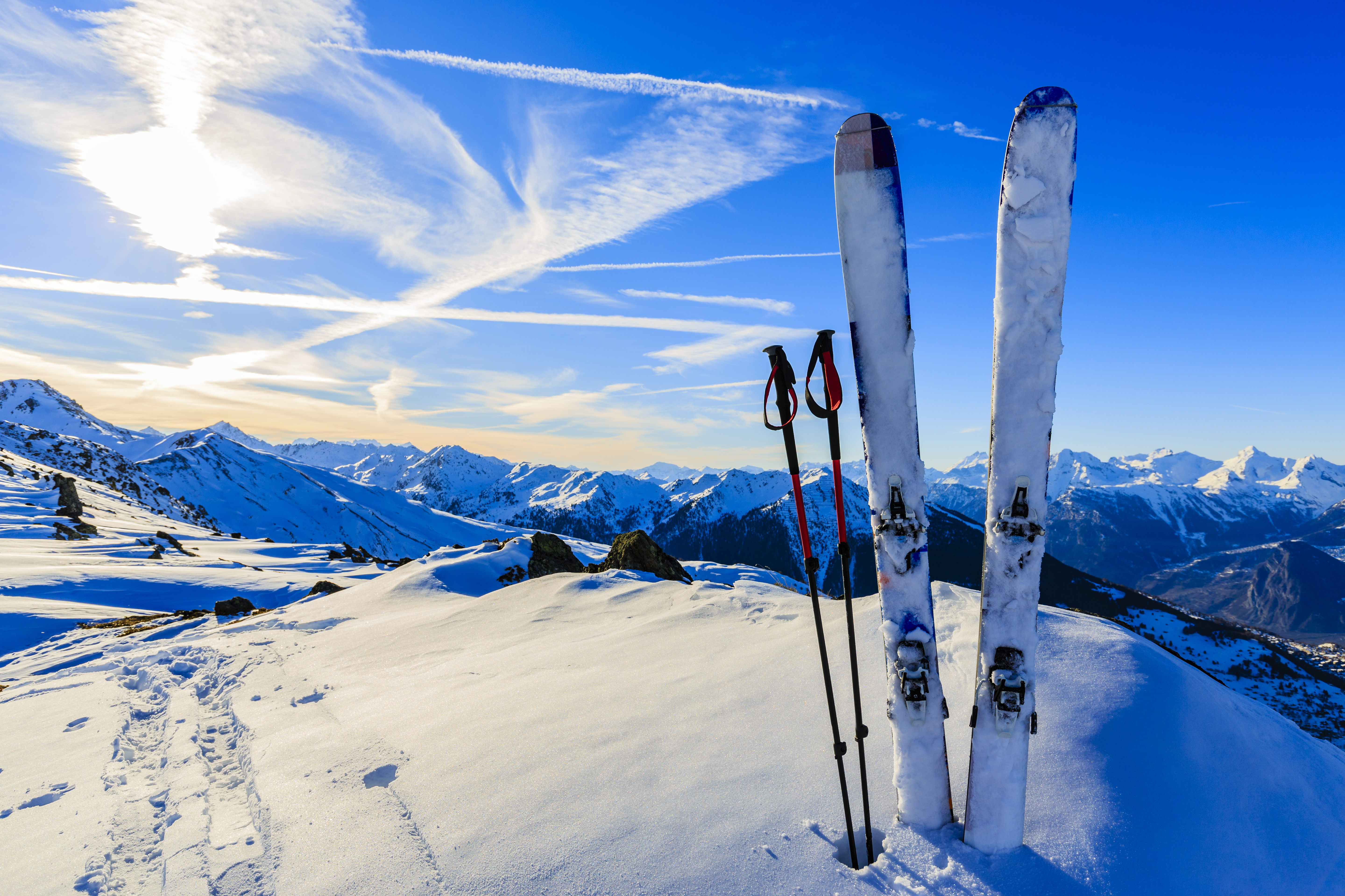 Skier auf der Spitze eines Bergs mit Blick ins Tal