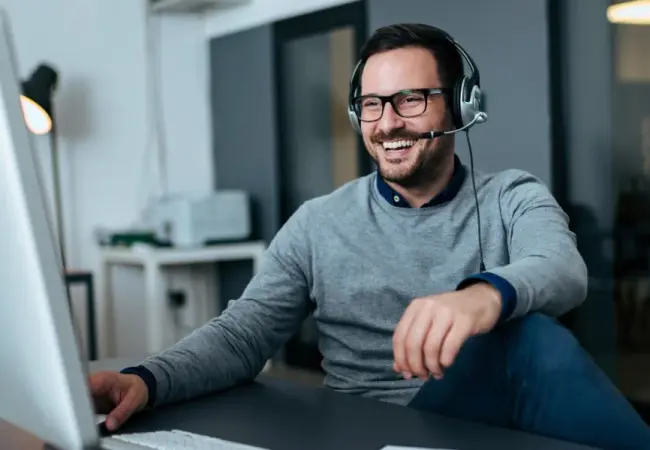 man sitting at computer with headset-scaled