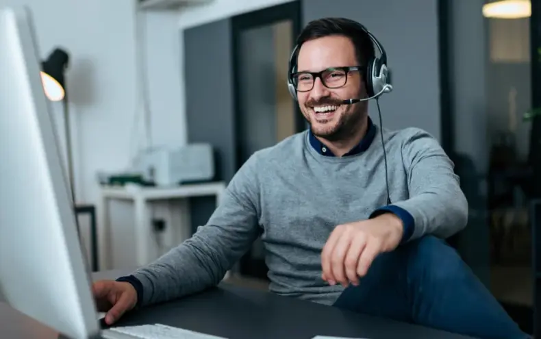 man sitting at computer with headset-scaled